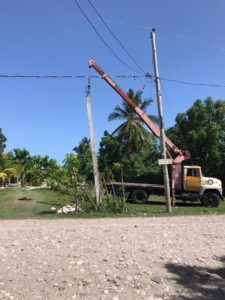 crane lifts post into hole