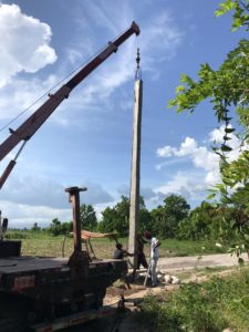 crane lifts post into hole
